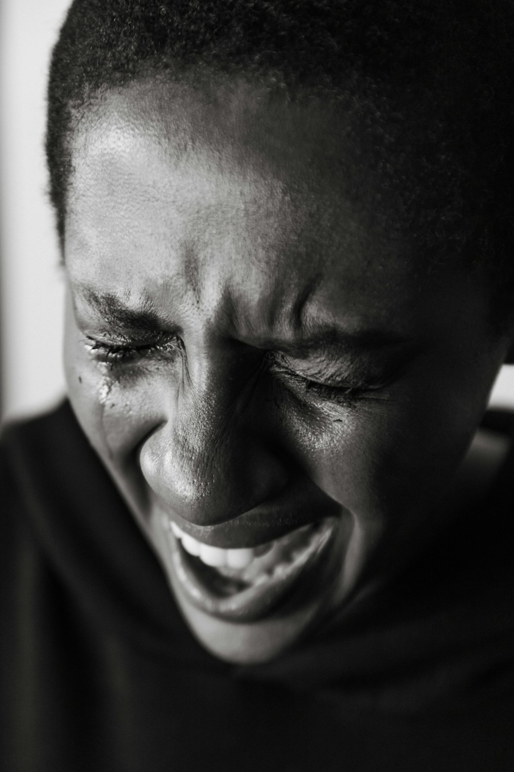 a woman laughing while holding a cell phone to her ear