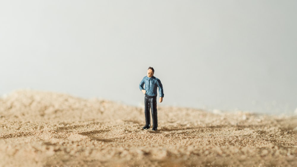 a toy man standing in the middle of a desert