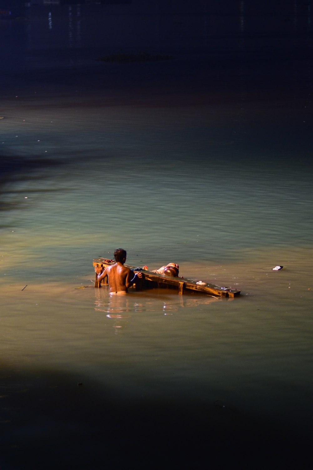 a man laying on top of a body of water