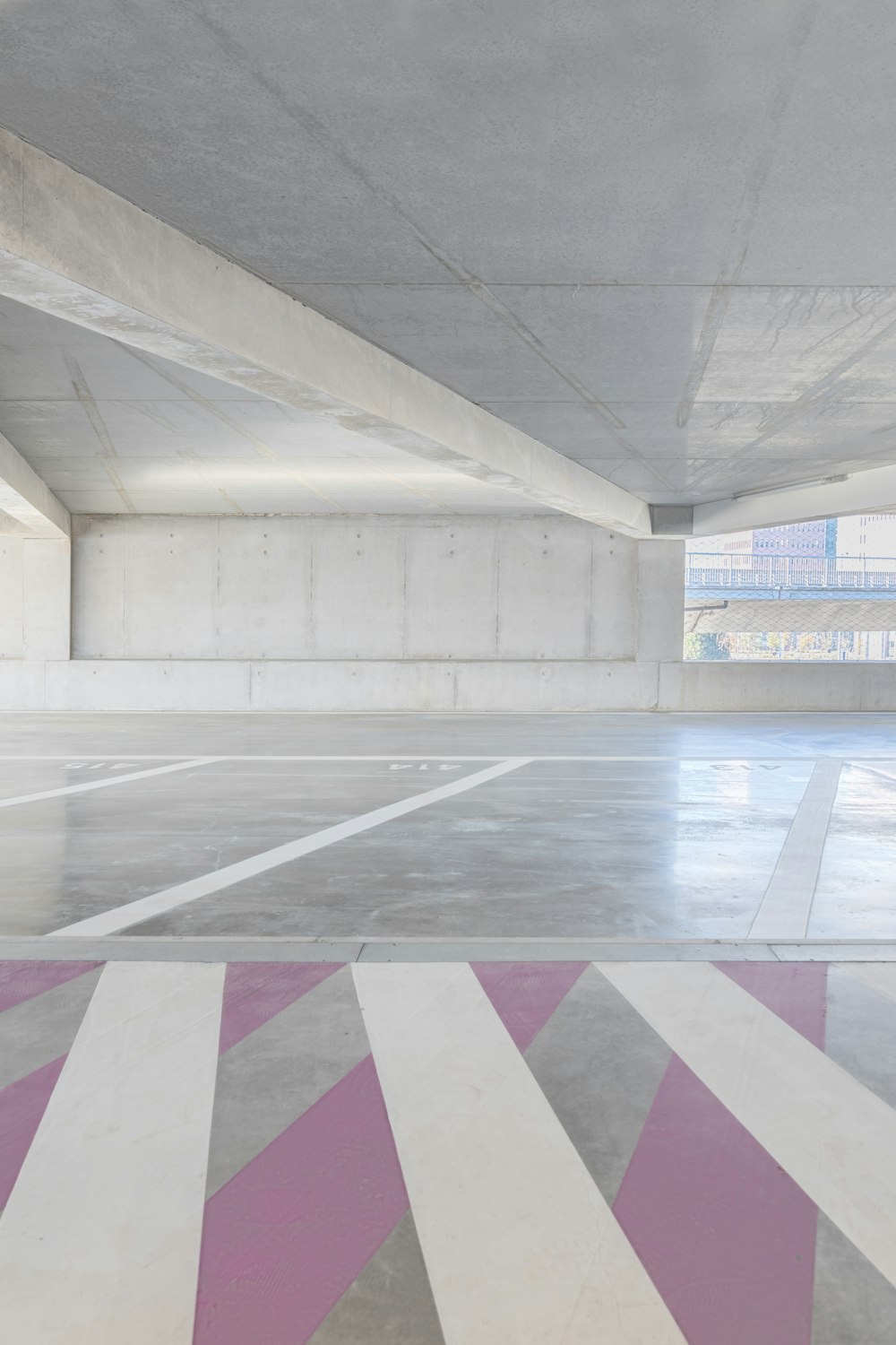 an empty parking garage with pink and white stripes
