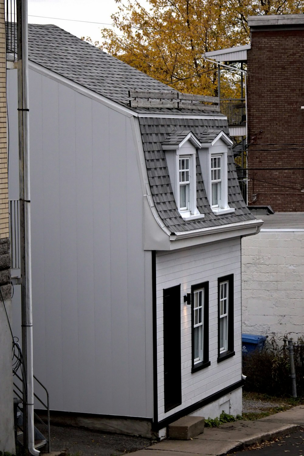 a small white house with a gray roof