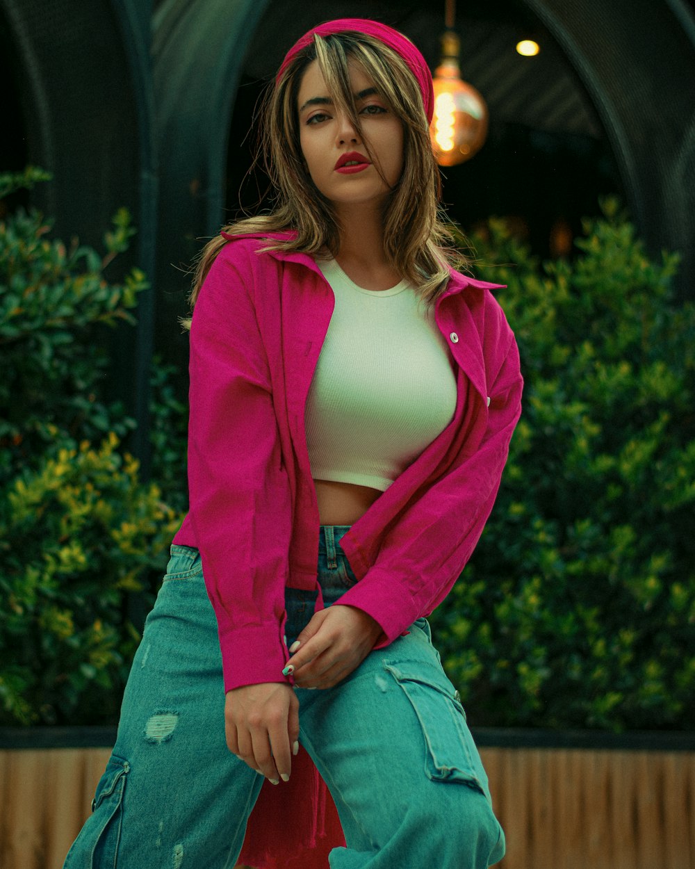 a woman in a pink jacket is posing for a picture