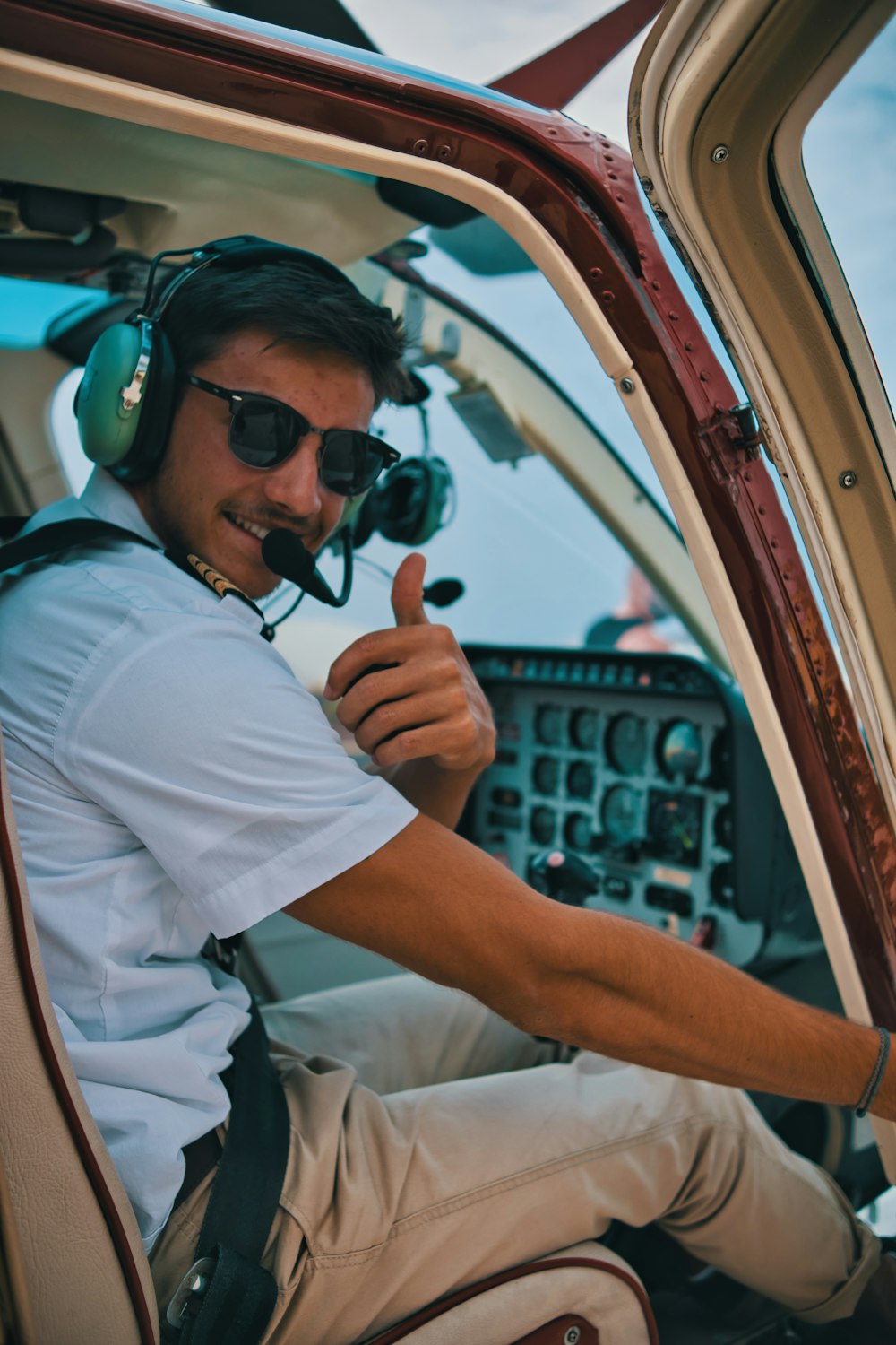 a man sitting in the cockpit of a plane giving a thumbs up