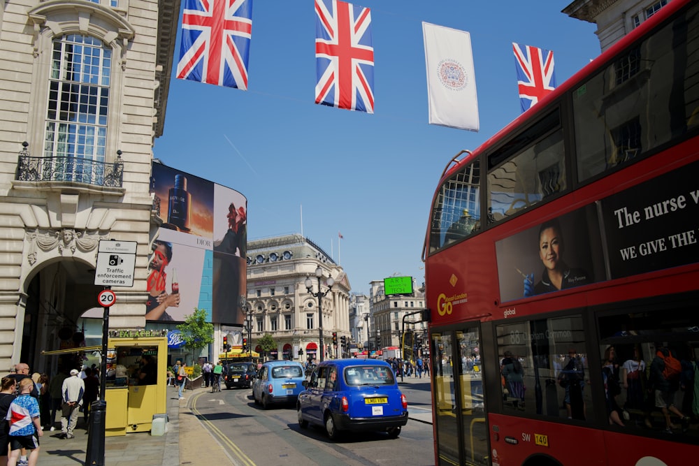 a red double decker bus driving down a street