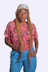a woman wearing a pink shirt and blue pants