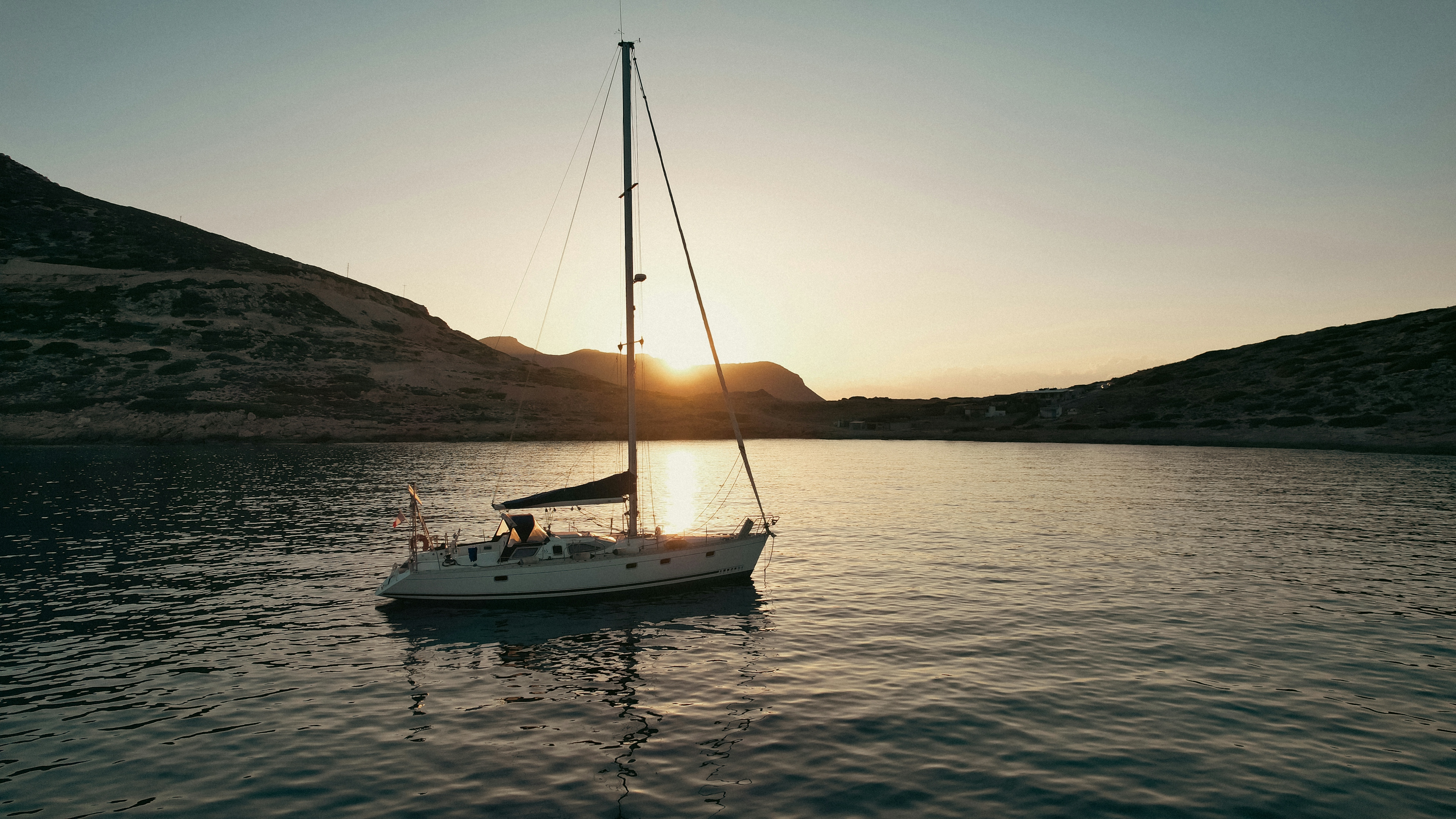 nella foto una barca a vela in mare sull'isola di creta al tramonto: ecco i locali e le discoteche da non perdere la sera