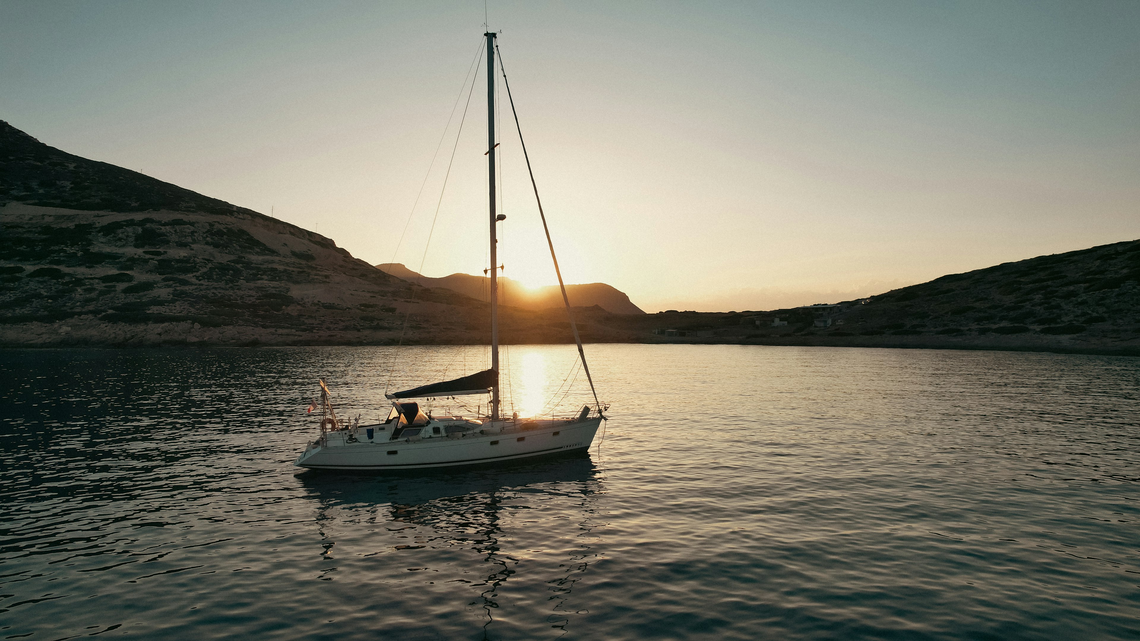 nella foto una barca a vela in mare sull'isola di creta al tramonto: ecco i locali e le discoteche da non perdere la sera