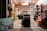 A well-lit storage room filled with a variety of items organized on shelves. A prominent sign in the foreground advertises a sale for items priced at $5 or less. The space is cluttered with various household goods, including furniture, toys, and decorations, creating a busy and eclectic atmosphere.