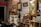 A room filled with an eclectic collection of vintage and retro items. Various framed artworks and memorabilia are displayed on the walls. A collection of small objects and antiques are arranged on shelves and cabinets, with decorative elements like glass bottles, figurines, and a lamp. The ambiance is nostalgic, evoking a sense of history and charm.