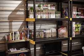 A vibrant display of retro Japanese video game cartridges and consoles arranged on a wooden shelf.