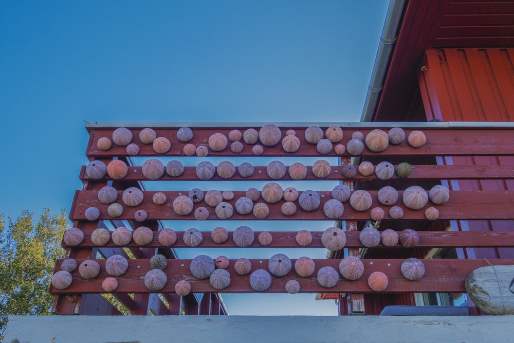 a red wooden structure with a bunch of balls on it