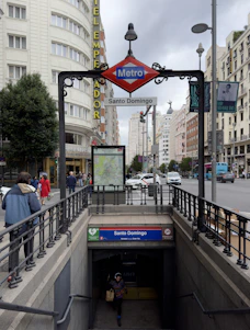 A vibrant street scene in Santo Domingo with locals reading newspapers and using smartphones.