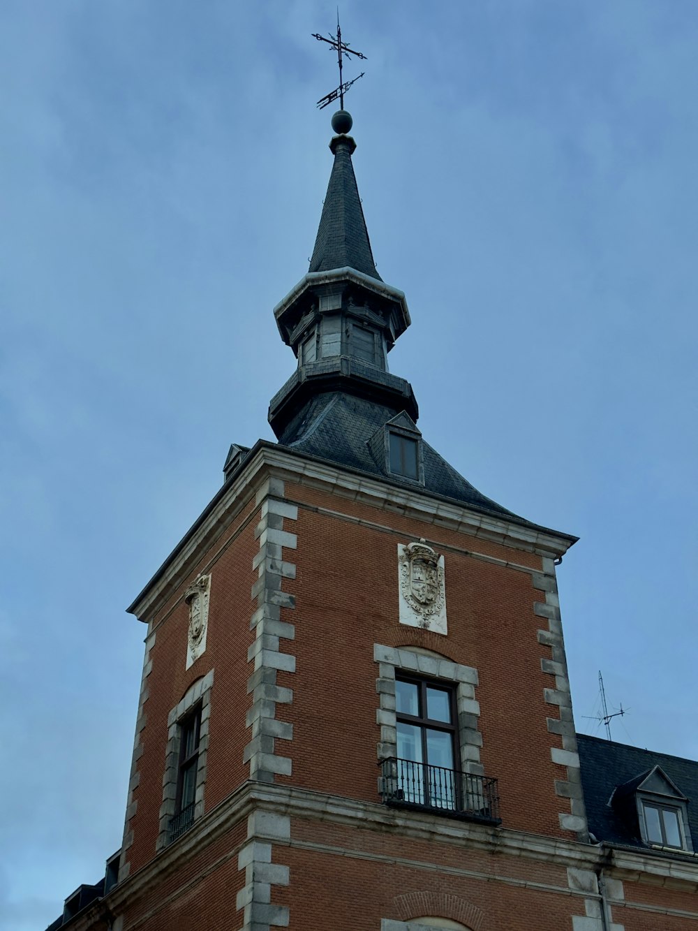 a tall brick building with a clock on the top of it