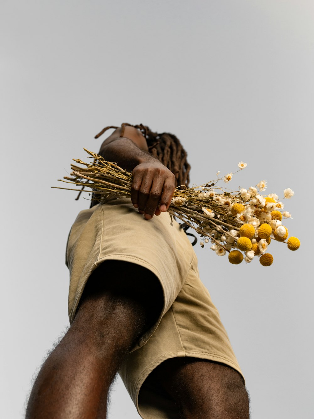 a man holding a bunch of yellow flowers