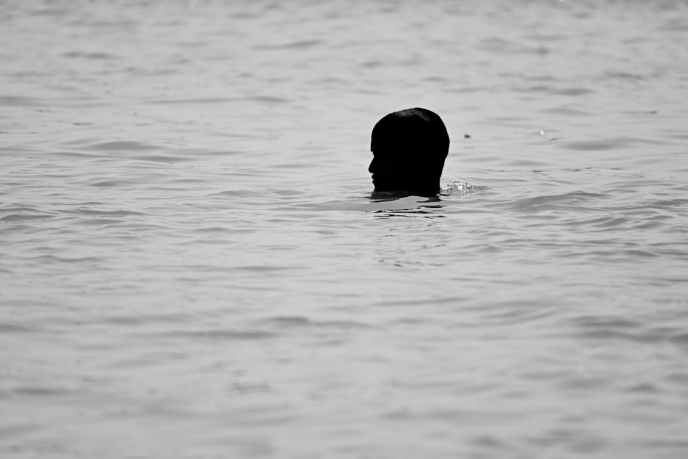 a black and white photo of a person in the water