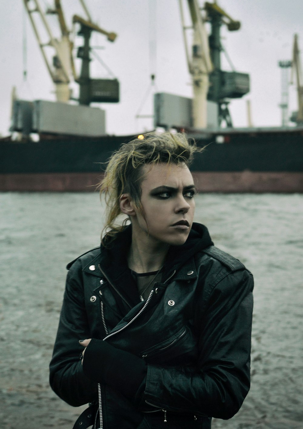 a woman with black makeup standing in front of a boat