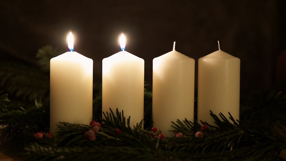 three white candles sitting on top of a table