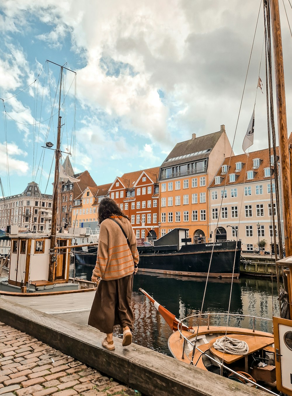 a person walking on a dock next to a body of water