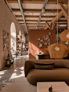 Interior of a modern bungalow with natural wood finishes and soft beige textiles.