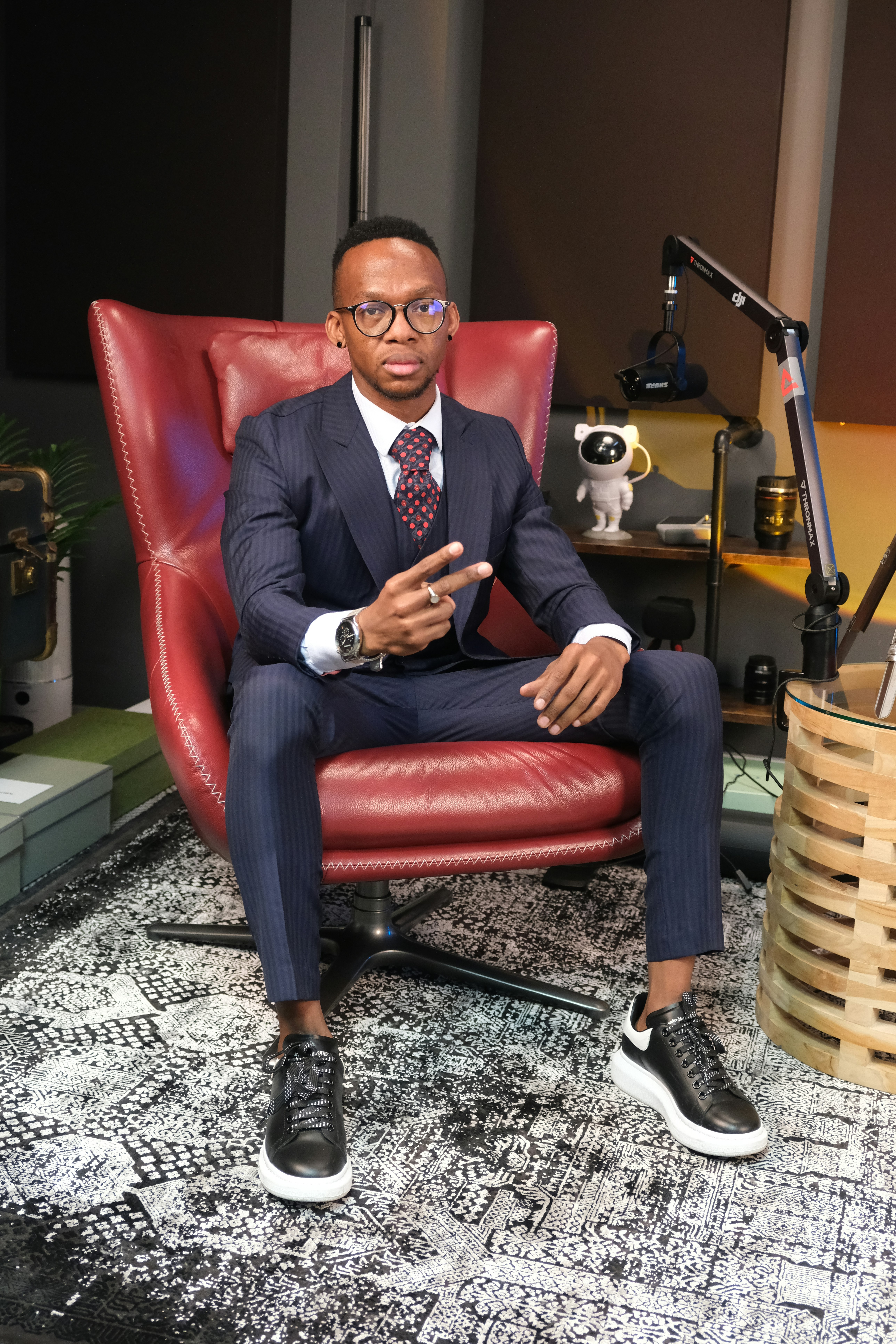 A man in a suit sitting in a red chair photo – Free Suit Image on Unsplash