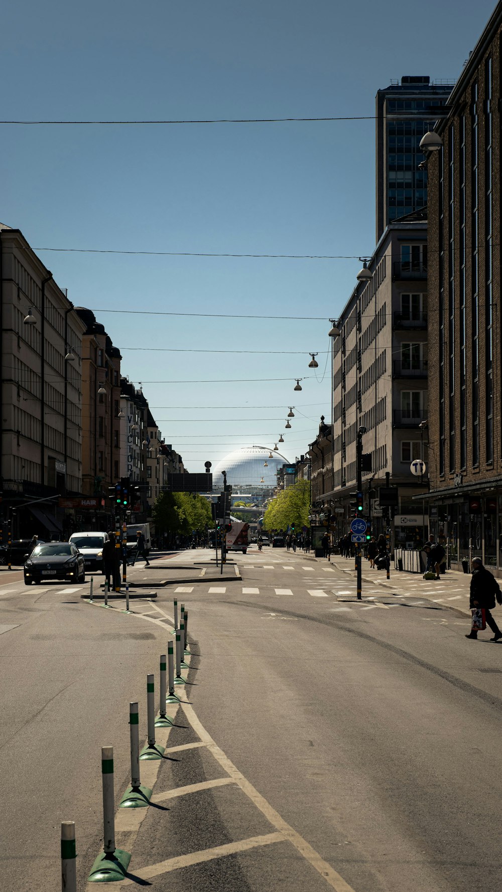 Eine Stadtstraße mit Autos und Menschen, die die Straße überqueren