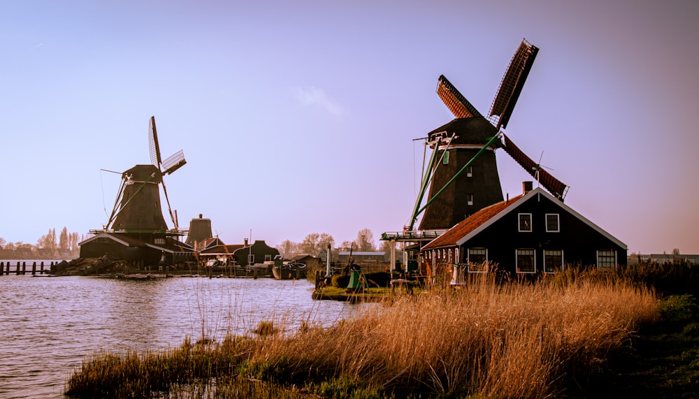 two windmills sitting next to a body of water