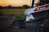 Close-up of skid steer tracks leaving marks on freshly laid gravel.