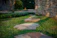 Close-up of a neatly edged garden path with natural stone borders under soft sunlight.