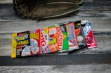 A collection of vintage baseball card packs, arranged in a row, displayed on a wooden surface with a baseball glove partially visible in the background.