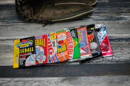 A collection of vintage baseball cards in protective sleeves arranged neatly on a dark surface.