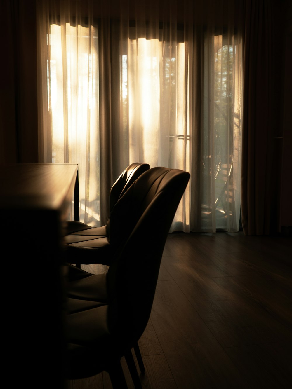 a dining room table and chairs in front of a sliding glass door