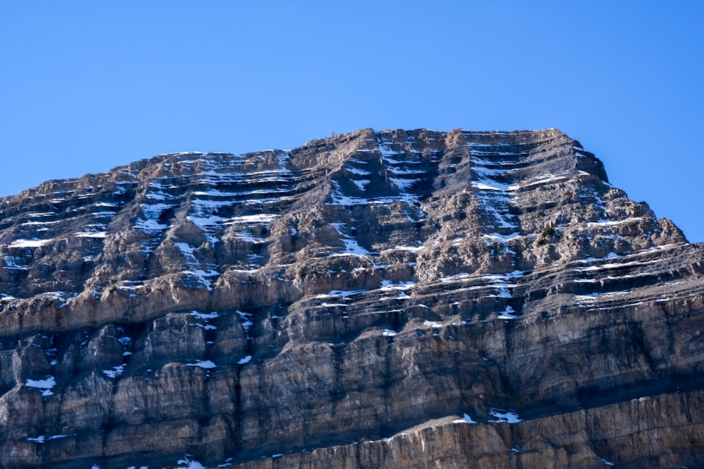 a very tall mountain covered in snow under a blue sky