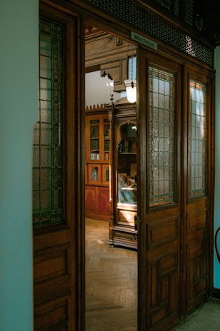 Hidden entrance behind the coffee shop’s bookshelf, slightly ajar revealing the club inside.