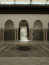 Elegant Moroccan riad courtyard bathed in warm sunlight with intricate tilework.
