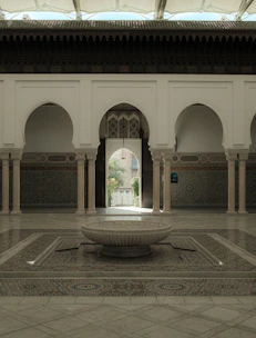 Elegant Moroccan riad courtyard bathed in warm sunlight with intricate tilework.