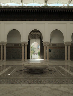 A cozy Moroccan riad courtyard bathed in warm golden light with intricate mosaic tiles and lush greenery.