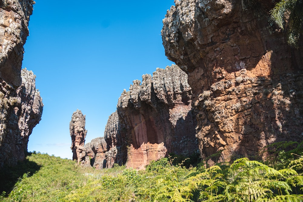 a group of large rocks sitting on top of a lush green hillside