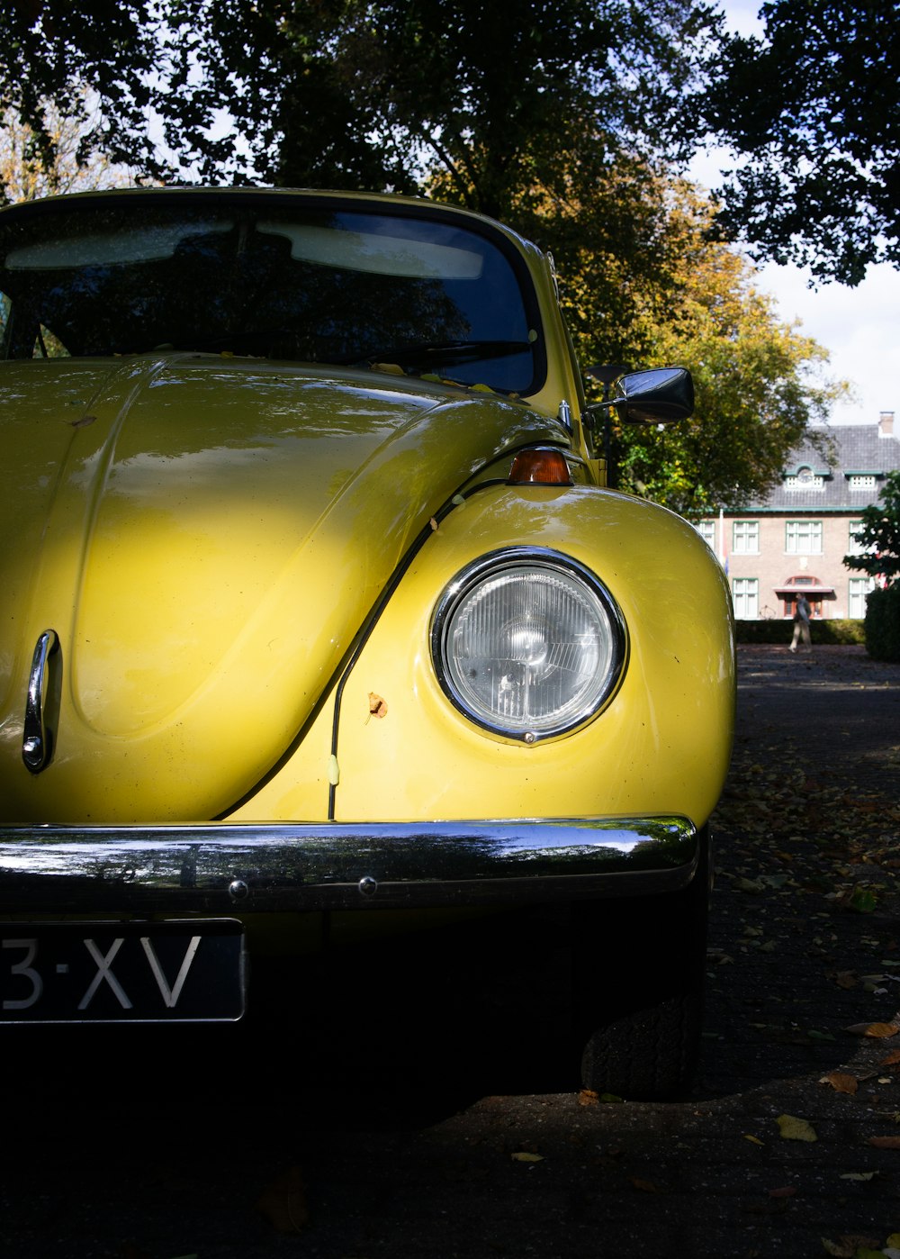 a yellow vw bug parked on the side of the road