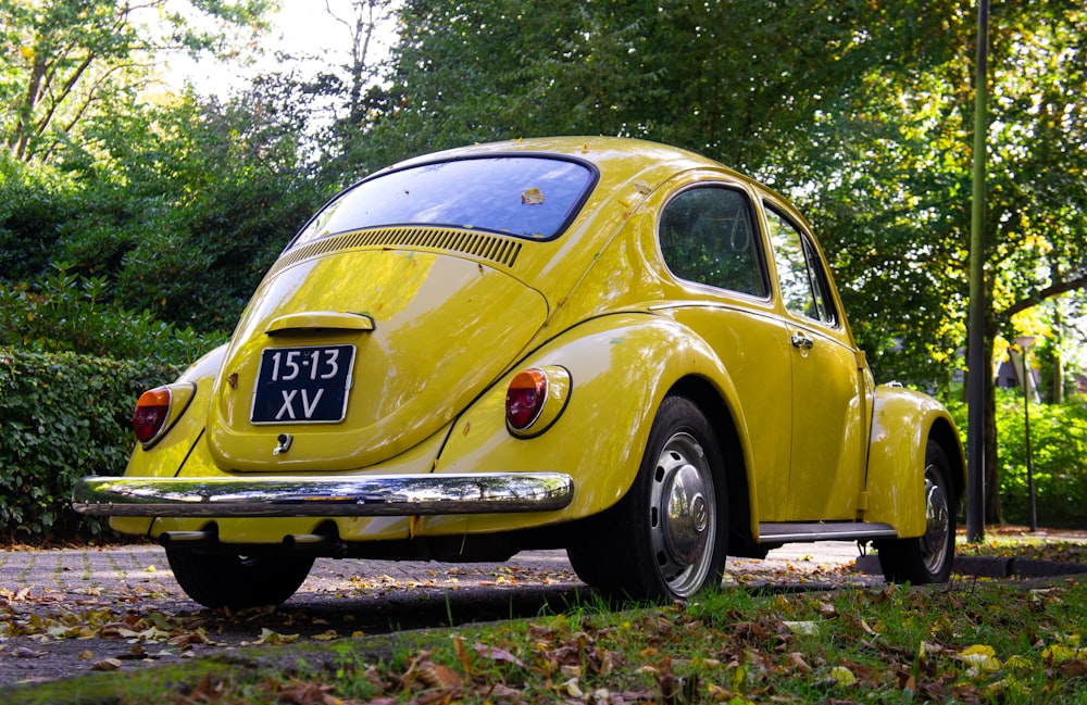 a yellow vw bug parked on the side of the road