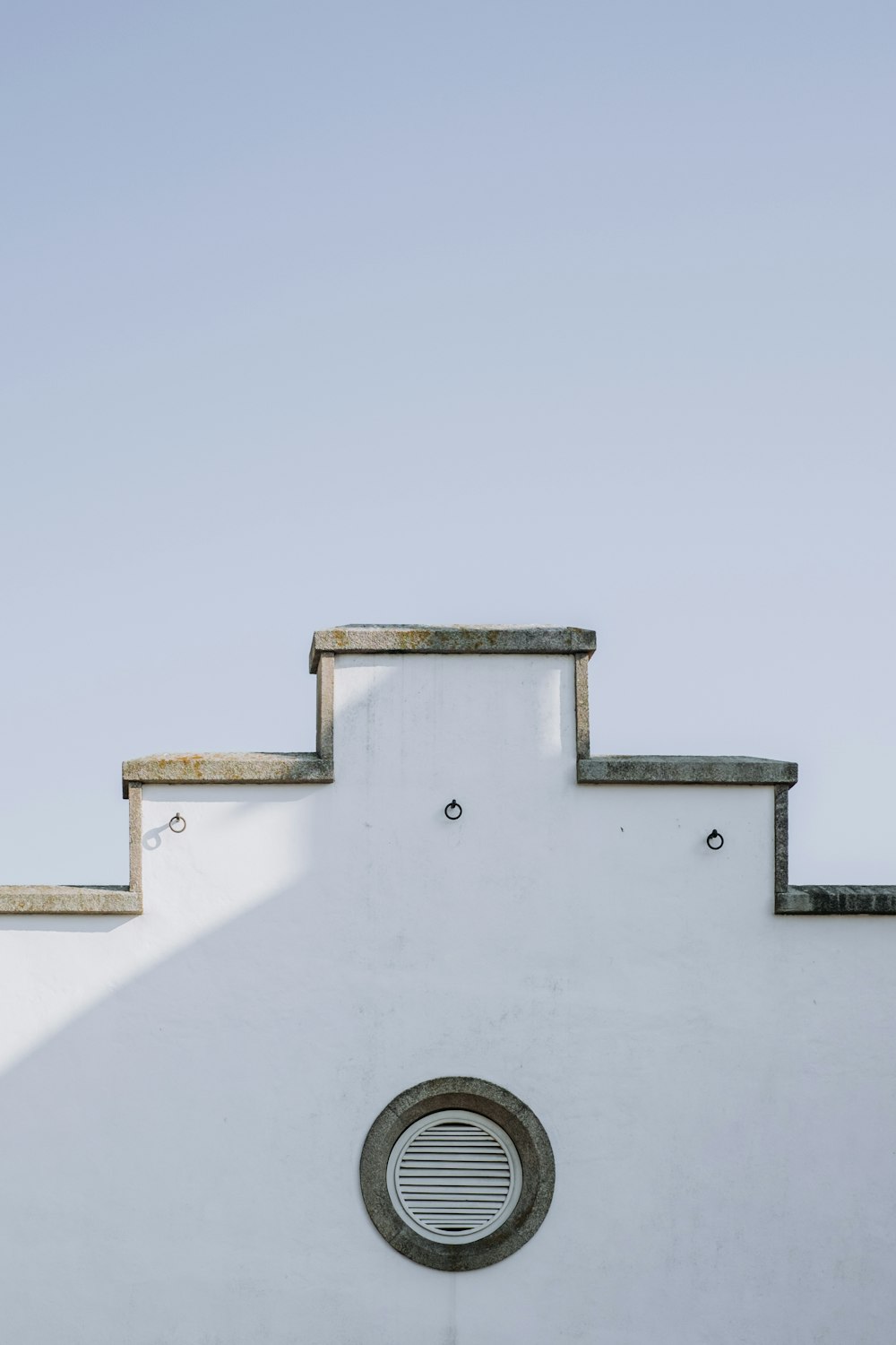 a white building with a round window on the side