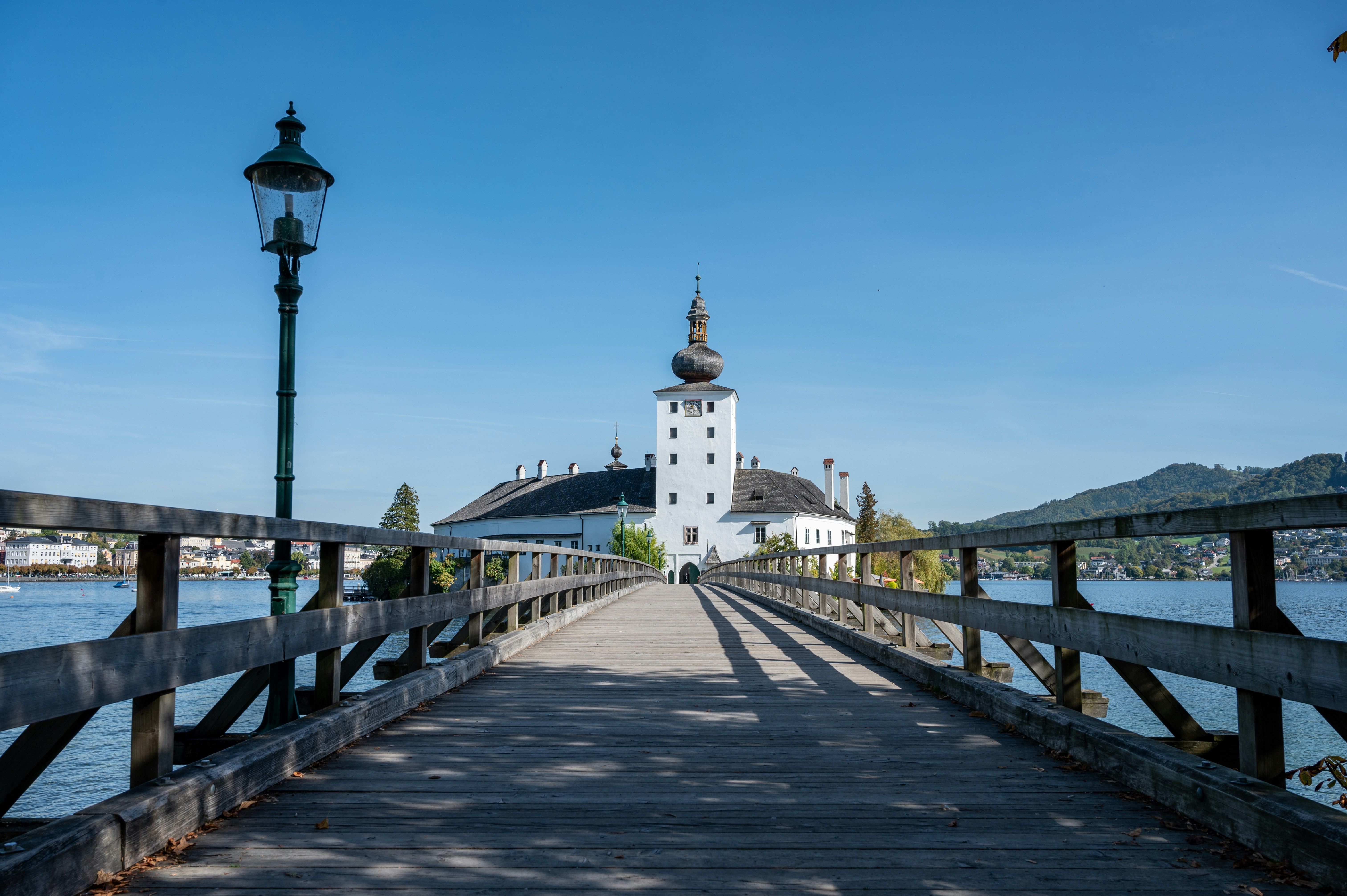 a wooden bridge with a white building in the background