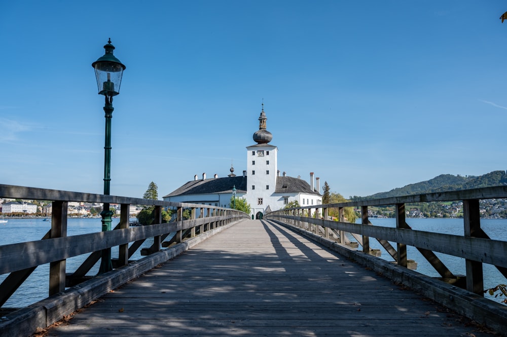 a wooden bridge with a white building in the background