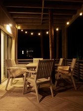 A cozy patio setup featuring a breathable wicker chair and glowing outdoor string lights at dusk.