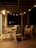 Photo of a cozy patio softly lit by warm white solar garden lights at dusk.