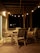 A warm, inviting wooden deck with comfortable seating and string lights glowing at dusk.