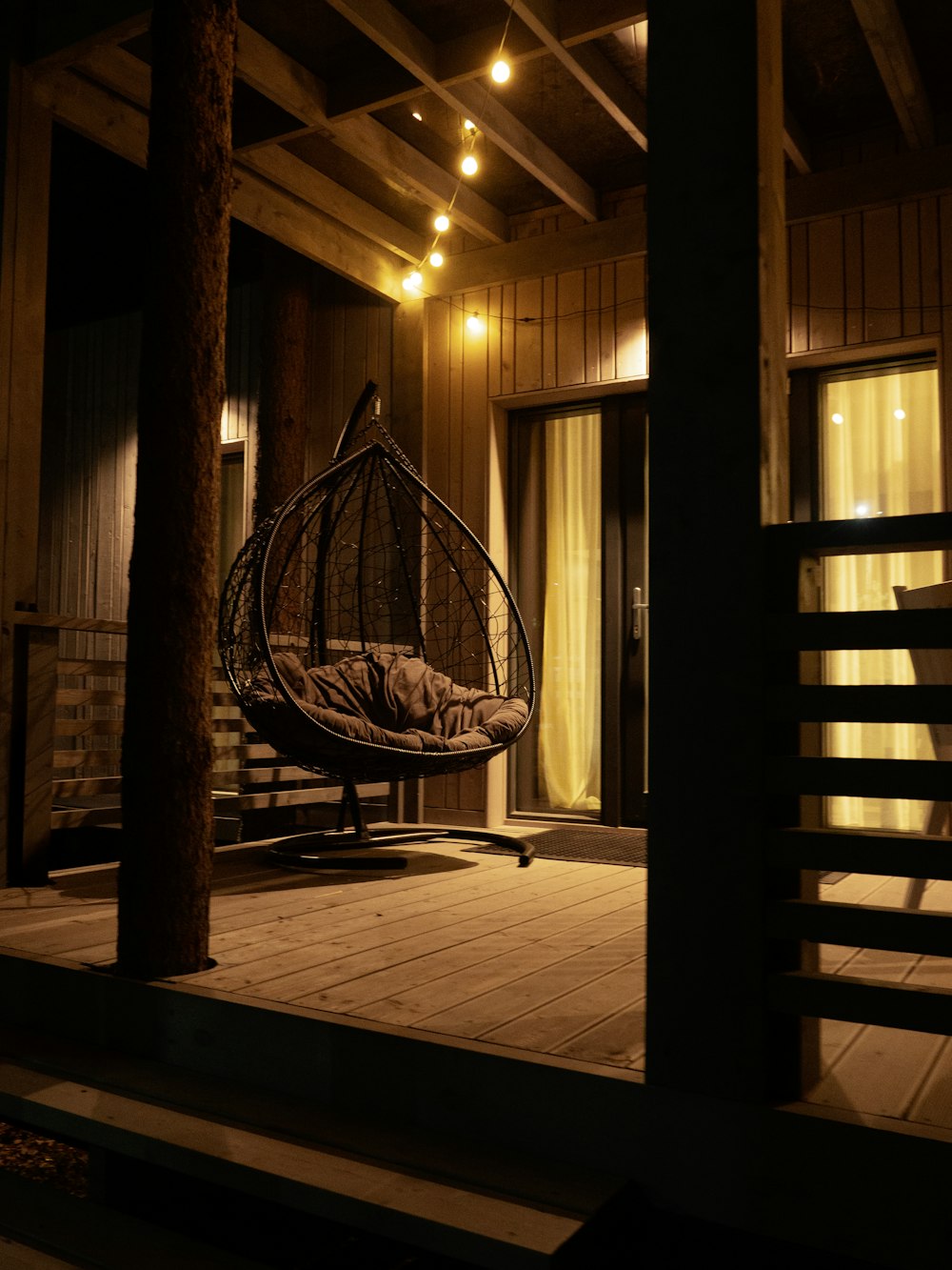 a hanging chair on a porch at night