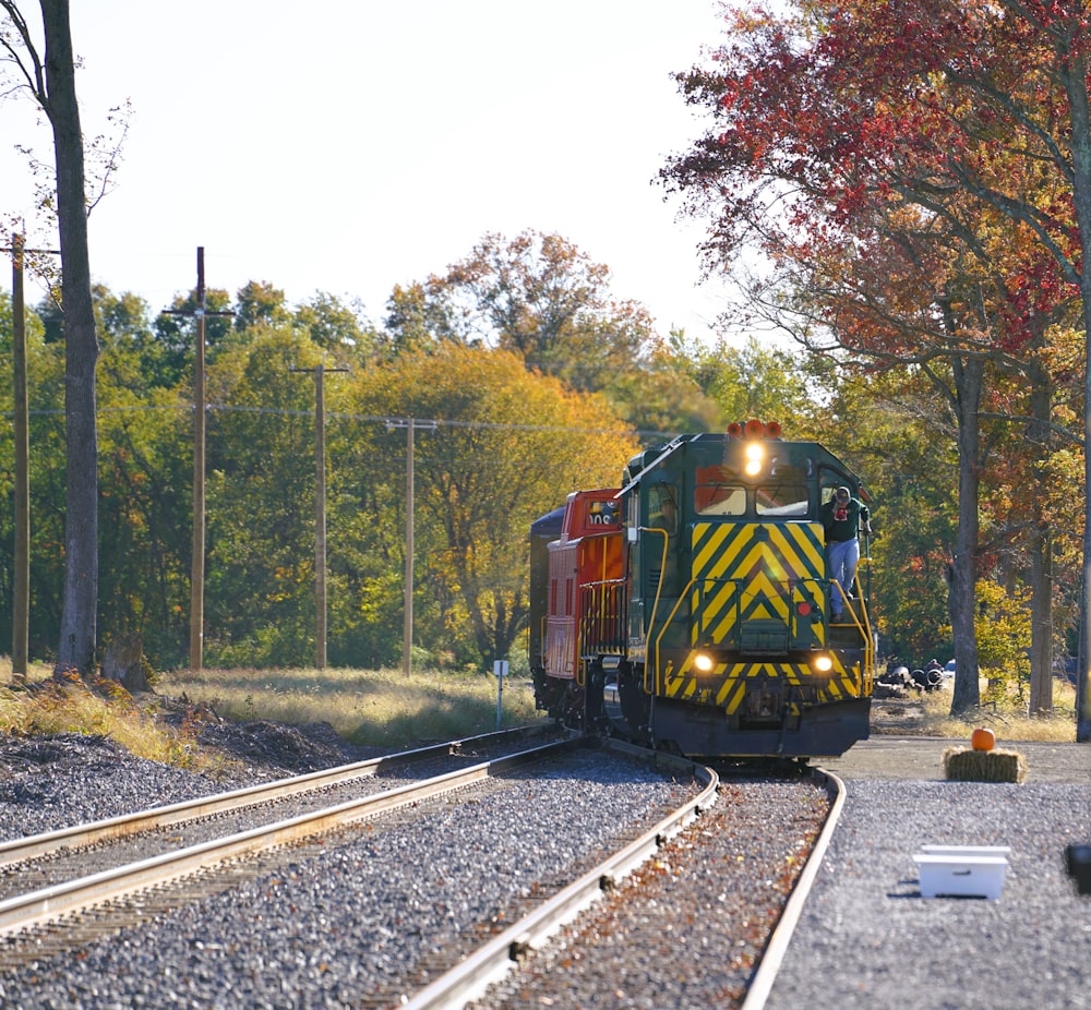 a train traveling down train tracks next to a forest