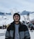 a man standing in front of a snow covered ski slope