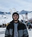 a man standing in front of a snow covered ski slope