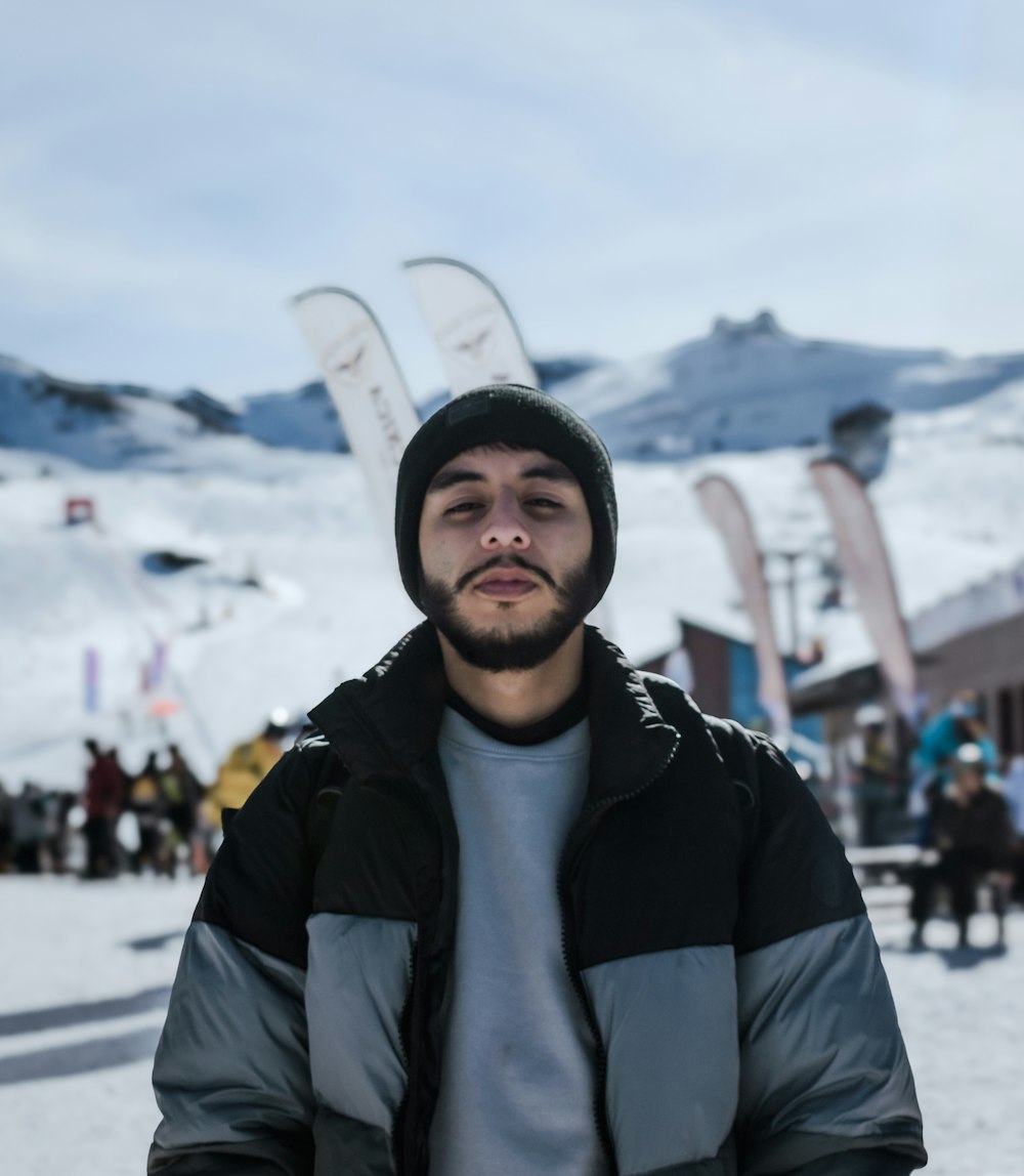 a man standing in front of a snow covered ski slope